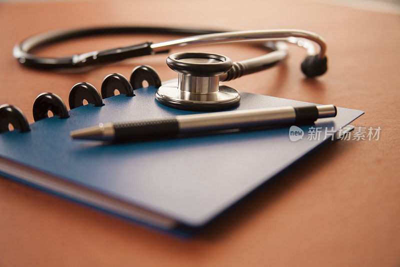 桌上放着医生的听诊器和记事本。