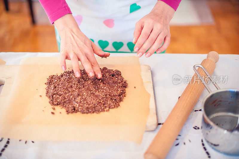在木砧板上准备巧克力面团的女人