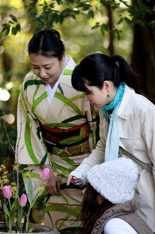 一个女人在咖啡厅前看花