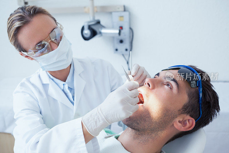 女牙医正在检查男子的牙齿