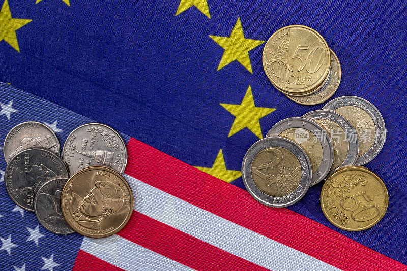 有硬币的欧洲和美国国旗。