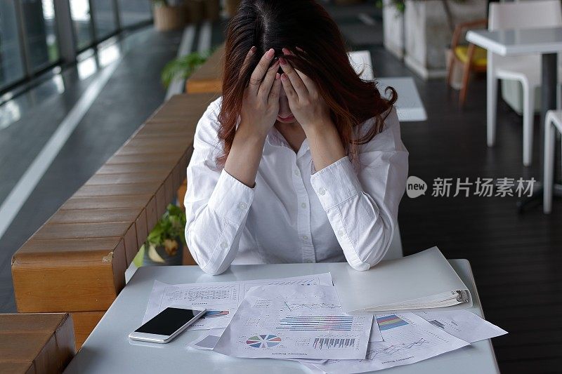近距离关注压力沮丧的年轻亚洲商业女性覆盖脸与手在办公桌上的办公室