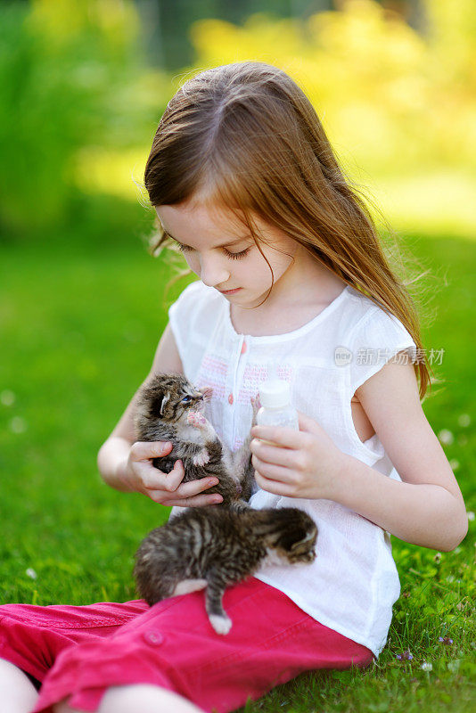 可爱的小女孩和小猫一起玩