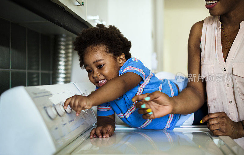 非洲裔小孩帮妈妈洗衣服