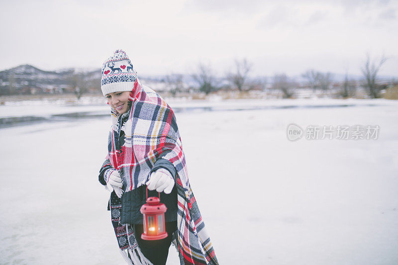 年轻女子在雪地里提着灯笼