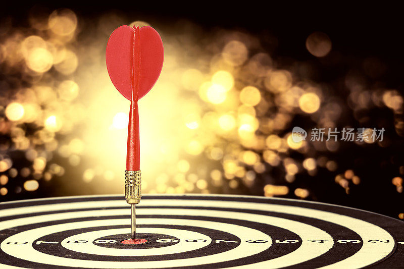目标飞镖与箭头在模糊的散景背景，隐喻目标营销或目标箭的概念。