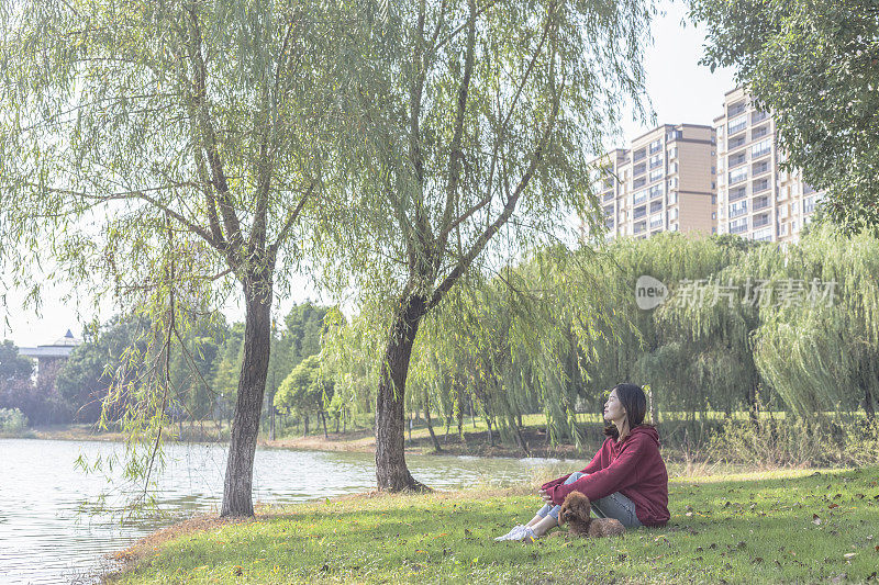 一个女人和她的小狗在湖边玩耍