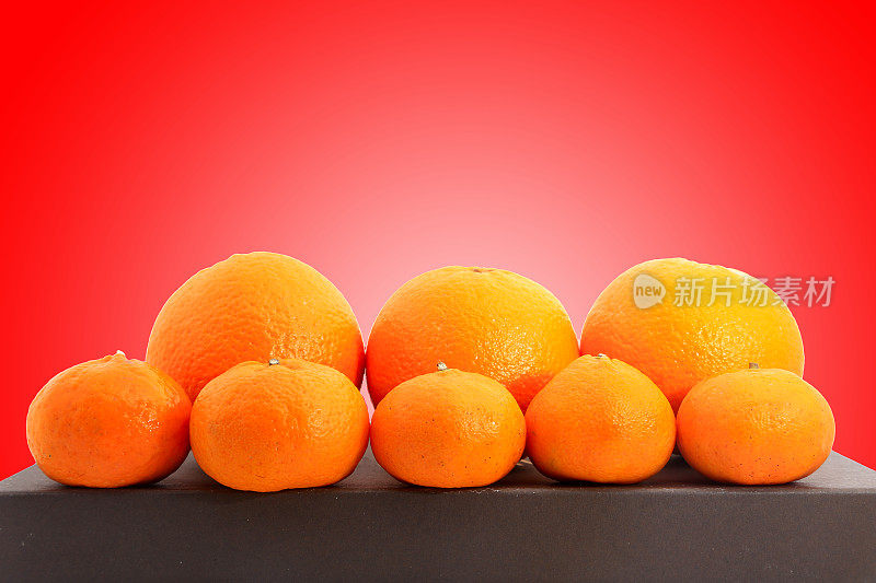 大大小小的蜜橘和柑桔在红色的背景上射出