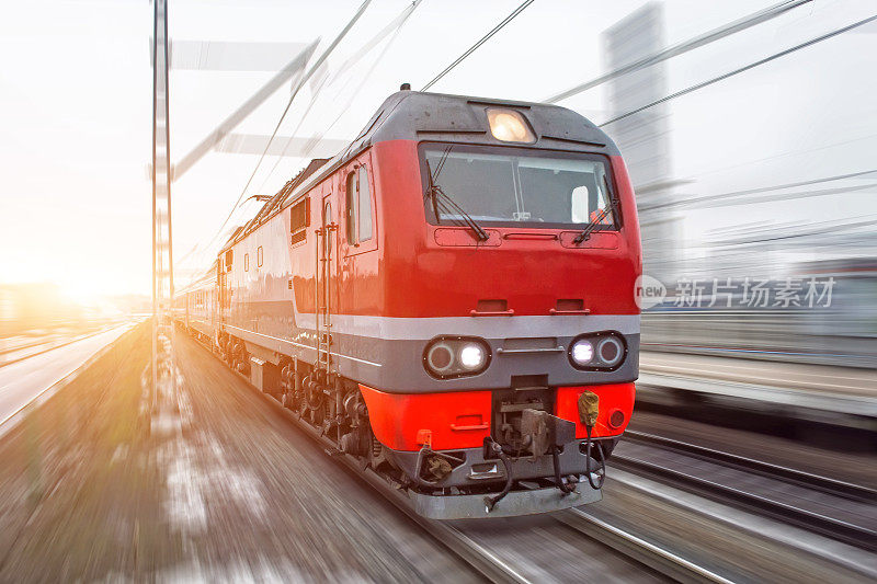 红色的高速客运列车在黄昏时分飞驰过铁路。