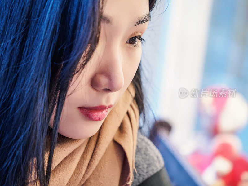 特写时尚美丽的中国女人肖像长头发看着橱窗，聚焦眼睛。