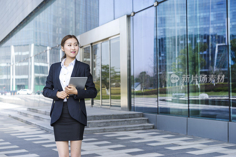 一个女商人在城市里拿着平板电脑的肖像