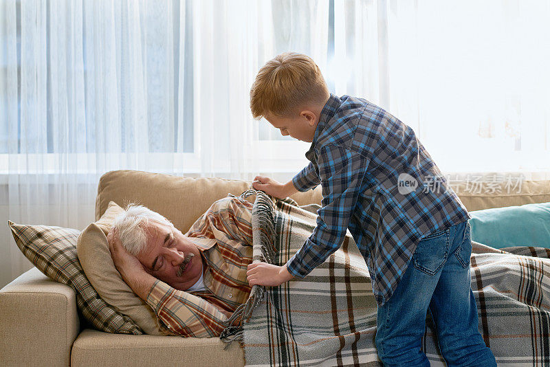 小心翼翼的孙子给爷爷盖上毯子