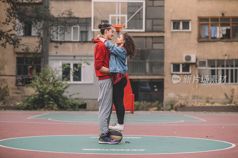 一对年轻情侣在篮球场