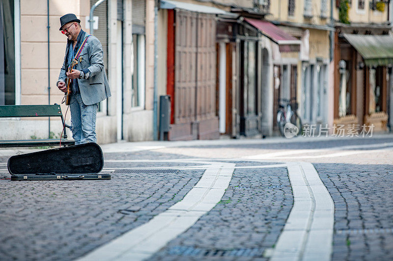在城市街道上弹奏电吉他的资深街头表演者
