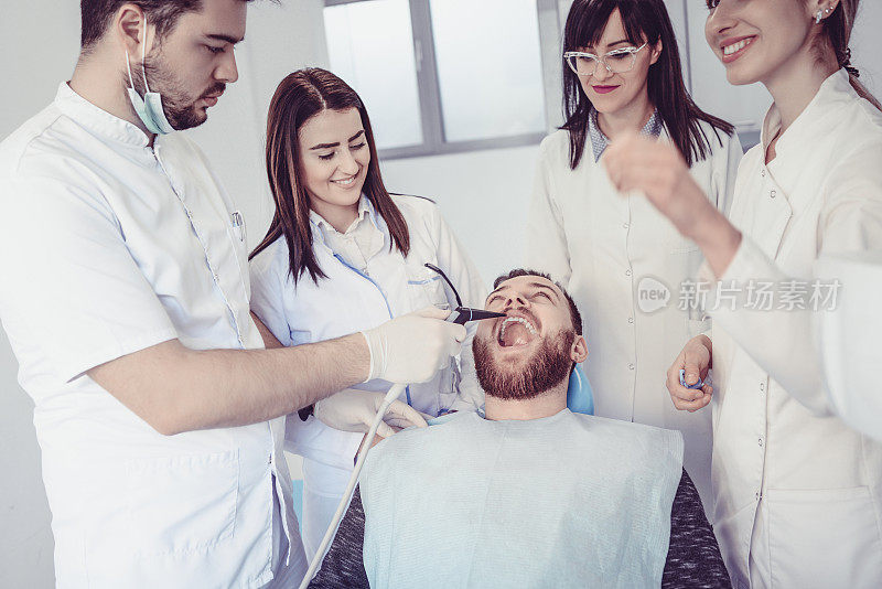 害怕的男性病人张开嘴进行牙齿治疗