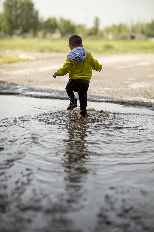 孩子们在雨坑里玩耍