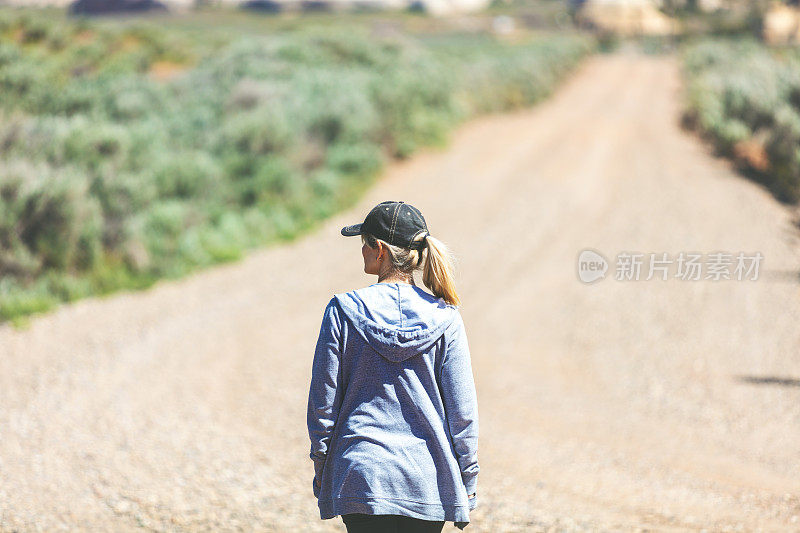 活跃美丽的成熟的成年女性户外在一个土路远足在西部科罗拉多