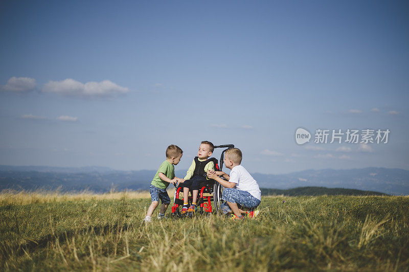 坐在轮椅上的小男孩和兄弟们一起活动