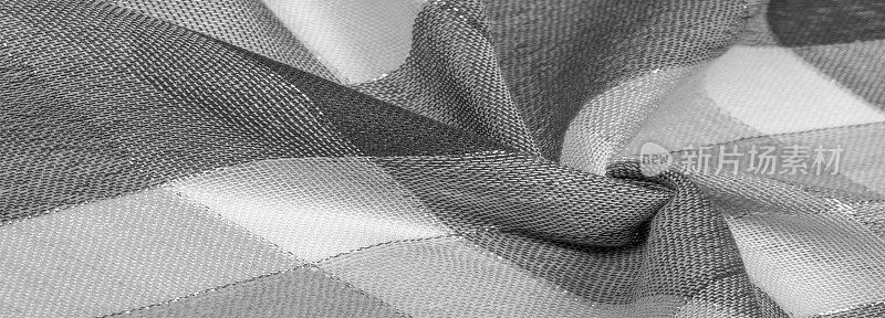 纹理、背景、丝巾女性化黑白带金属条纹。这条围巾以柔和的色彩和抽象的苏格兰图案装饰着精致的拼接图案。检查面料