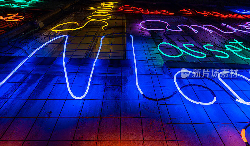 由霓虹灯和多种颜色的蓝色led灯以及红色和完全黑色的背景制成的发光字母和单词。爵士乐海报美学。电线和管子连接起来形成形状。