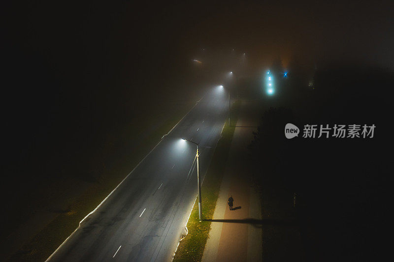 夜间雾蒙蒙的街道无人机摄影。道路和灯笼。轮廓。多雾的天气。糟糕的能见度。雾。大气神秘的景观。