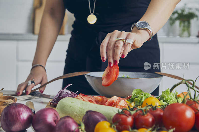 新鲜的有机蔬菜，在女人面前，在厨房里，为素食准备