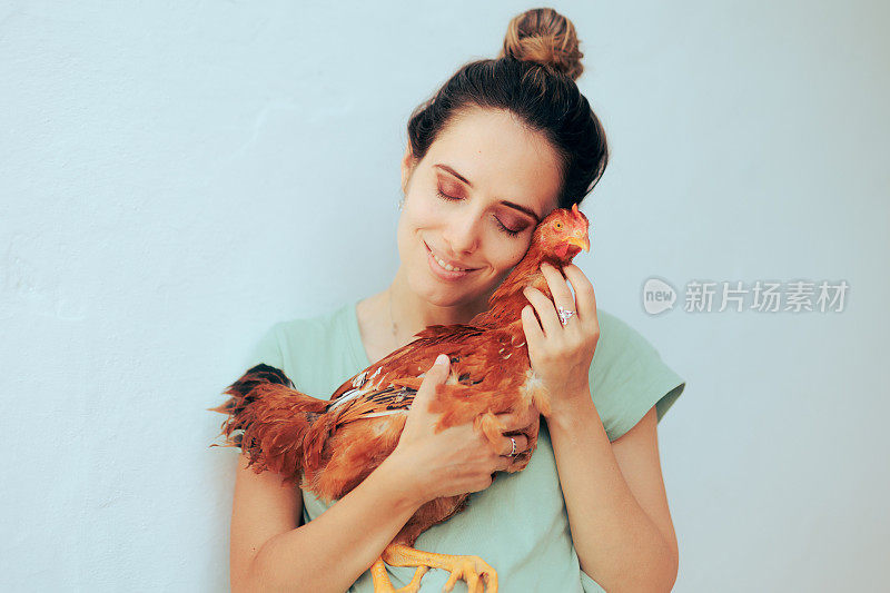 快乐微笑的女人抱着一只宠物鸡