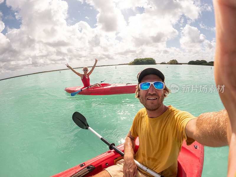 一对情侣在热带泻湖上划独木舟，享受国外假期，自拍
