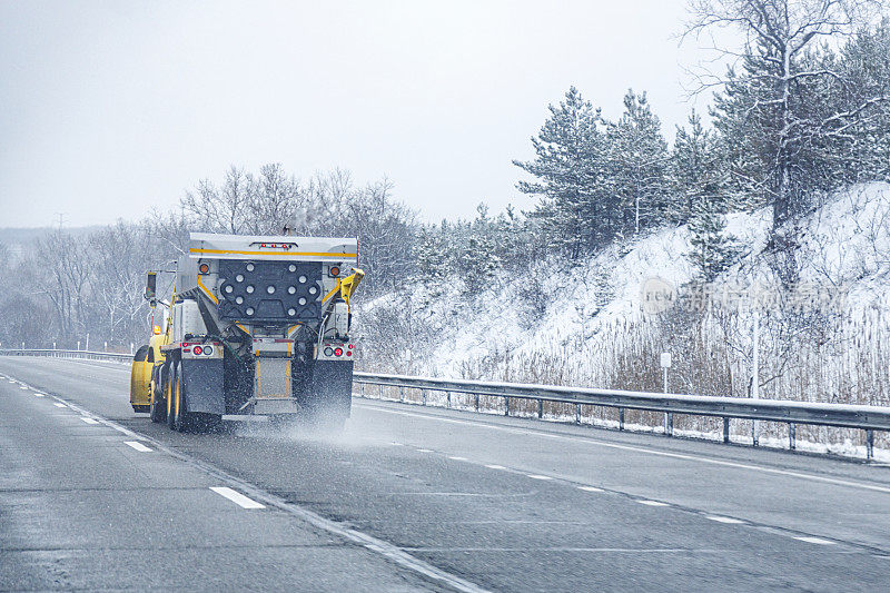 运输部铲雪车在路上撒盐