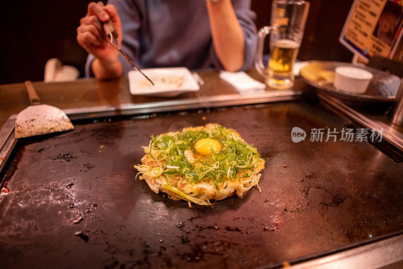 年轻女子在日本居酒屋酒吧烹饪御明烧