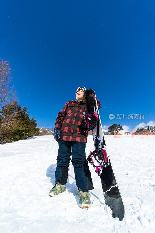 一个年轻快乐的老年滑雪板女子与她的滑雪板