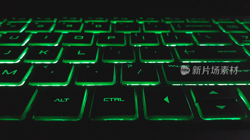 带绿色指示灯的Qwerty型笔记本电脑键盘。现代科技背景