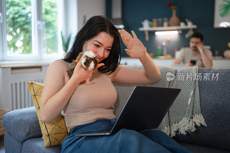 一个白人女人在和她的宠物，一只豚鼠视频通话