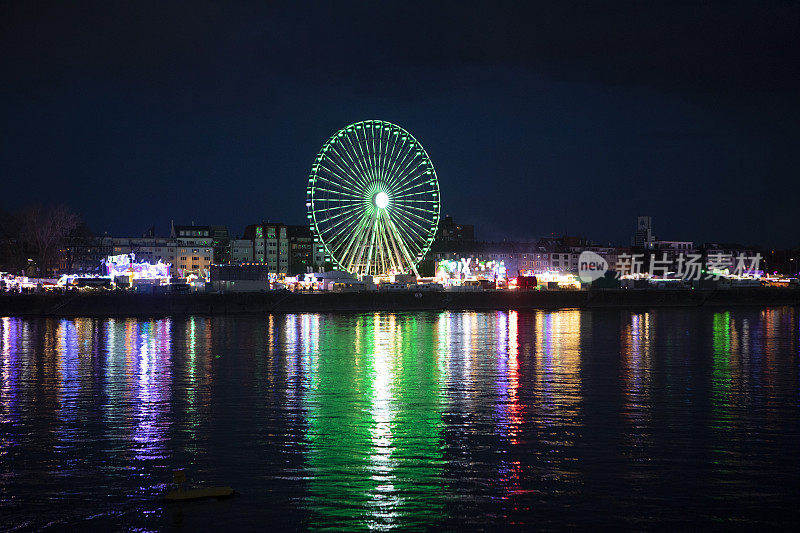 夜河上，灯火通明的大车轮和露天广场