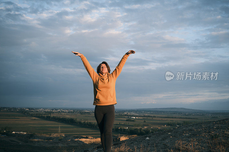 一位快乐的45岁妇女正在山上做晨练