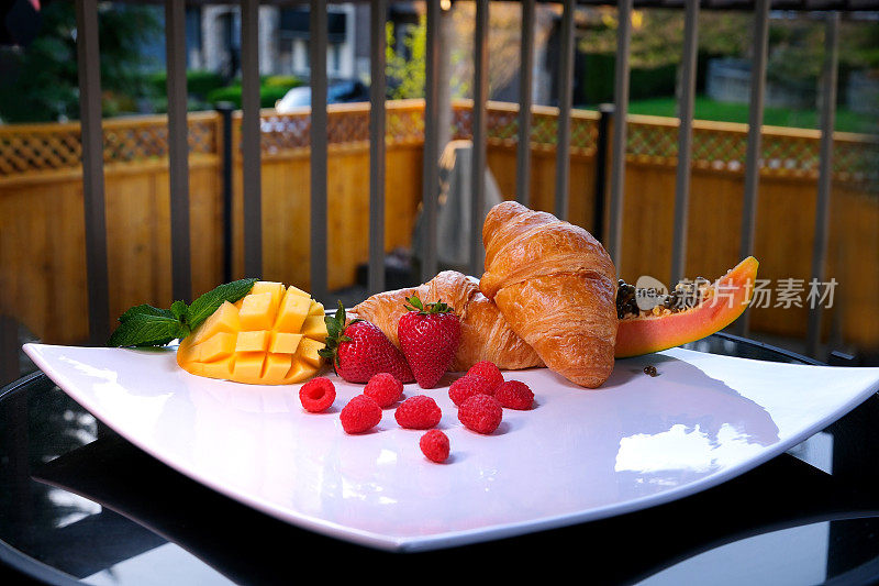 美丽美味的甜点在阳台上巨大的方形白色盘子热带副食水果牛角面包传统的法国午餐早餐美味的服务美丽的食物服务空间文字广告