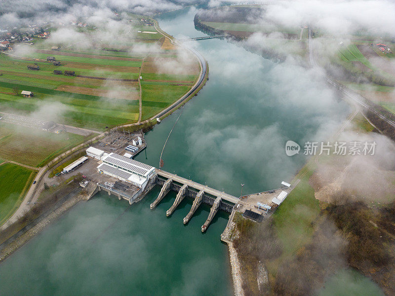 水力发电厂。水电站建在河上，农田沿着被云包围的洪泛区