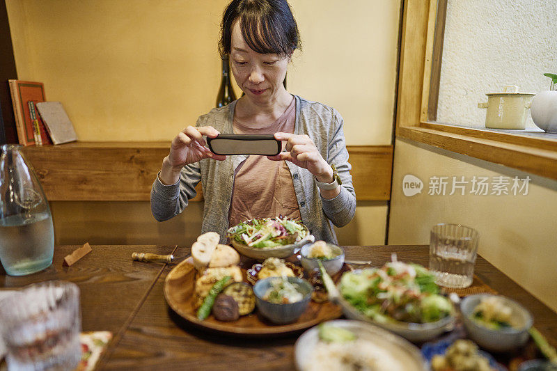 一位亚洲妇女在素食餐厅吃素食午餐。