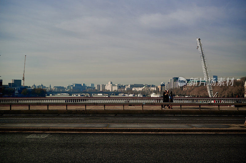 在黑衣修士桥上看伦敦的天际线，没有车辆，只有一小群人在阳光明媚的日子里走过