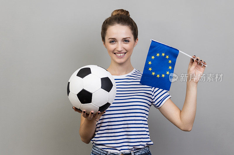 手持欧盟旗帜和足球的女子，在锦标赛上支持自己喜爱的球队。