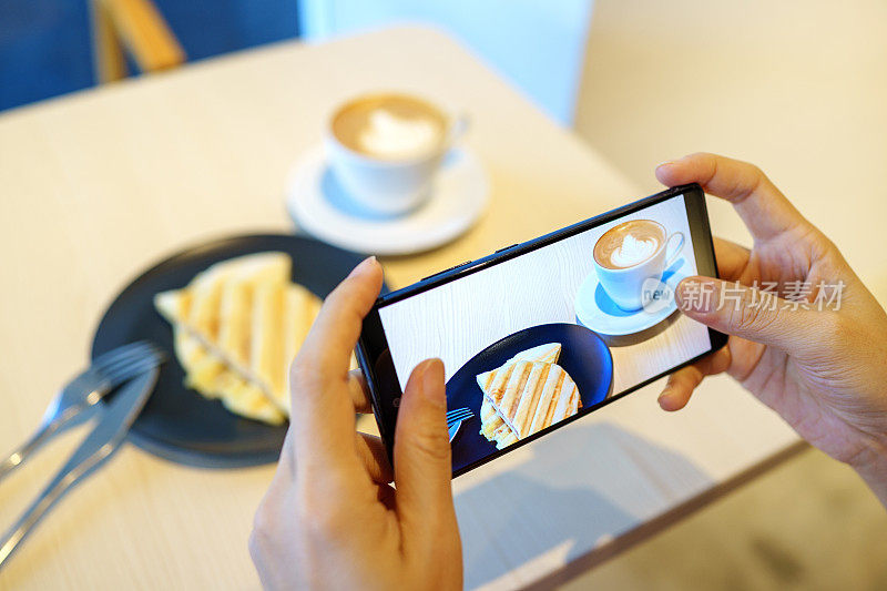 一位女士在用智能手机拍摄新鲜早餐时，抓拍到了她的手