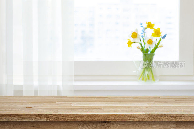空的木制桌面为产品蒙太奇和模糊的窗台与美丽的花朵