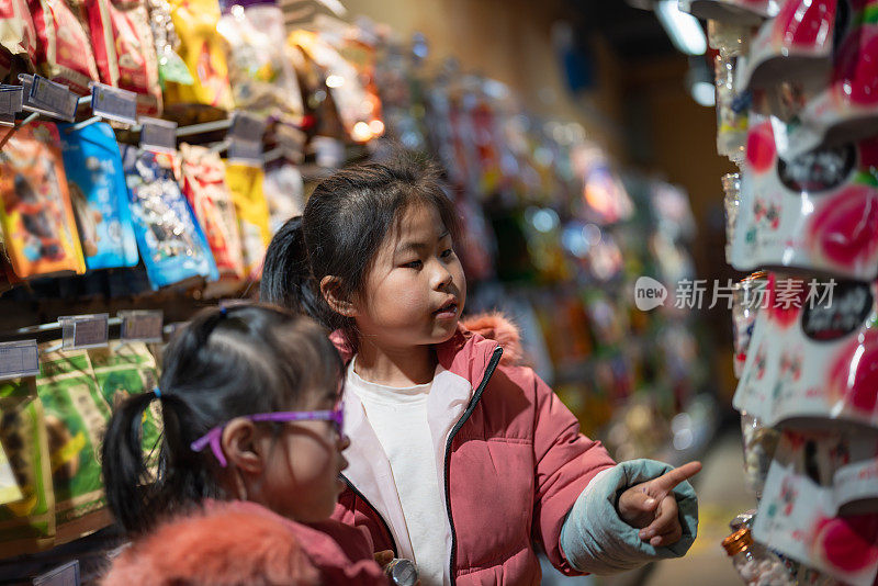 两姐妹在店里愉快地挑选零食