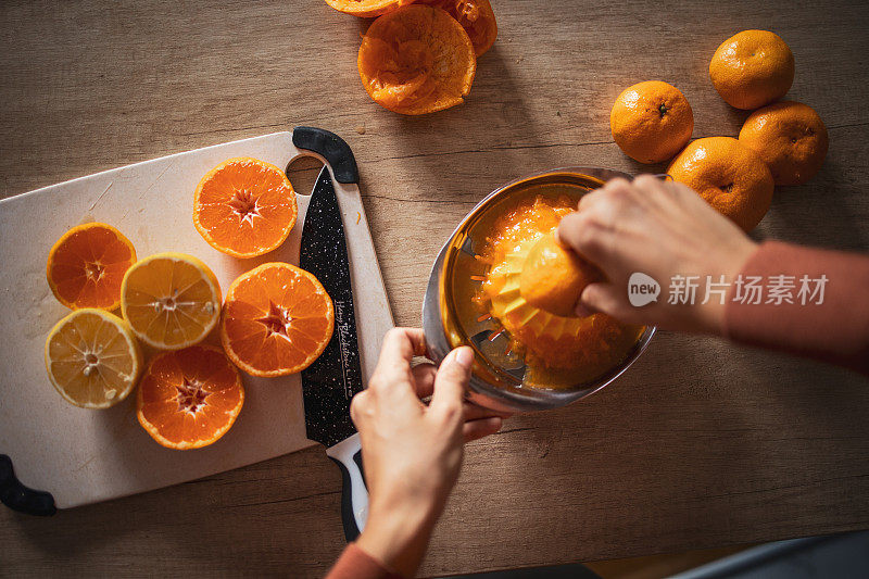 一个西班牙裔黑发女人在厨房准备橙汁的特写