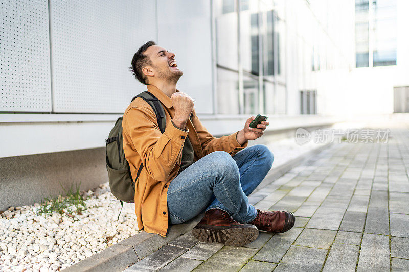 在智能手机上玩电子游戏的快乐男子