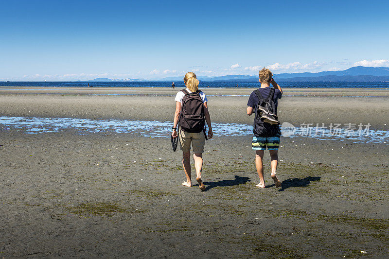 一对母子在加拿大不列颠哥伦比亚省的海边散步
