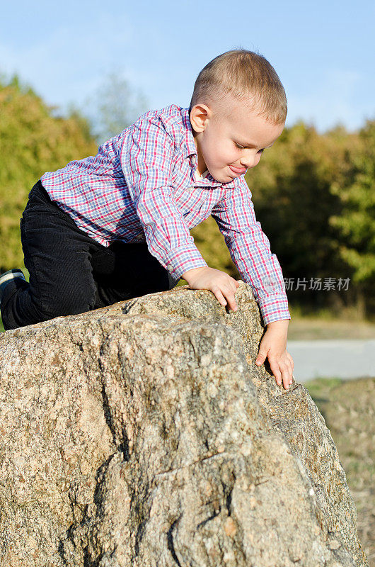 小男孩在爬岩石