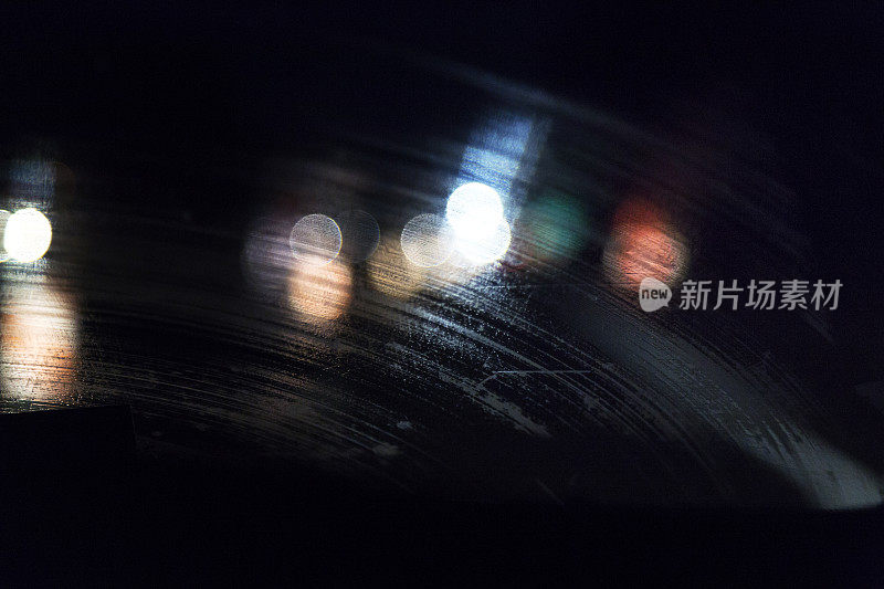 抽象的汽车灯通过条纹雨水夜汽车挡风玻璃