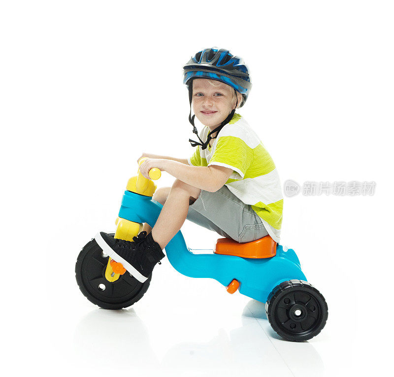 微笑的小男孩骑着三轮车