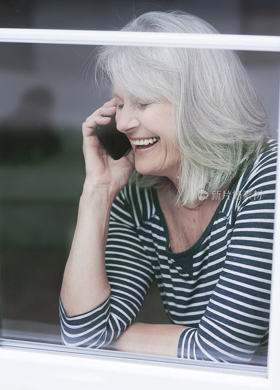 美丽微笑的老年妇女使用手机